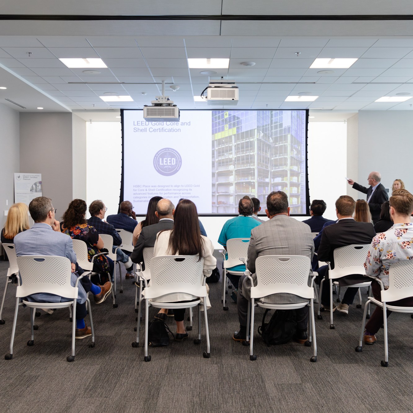 Image description: A group of participants listened to a speaker in a spacious, bright room. A group of participants listened to a speaker in a spacious, bright room.