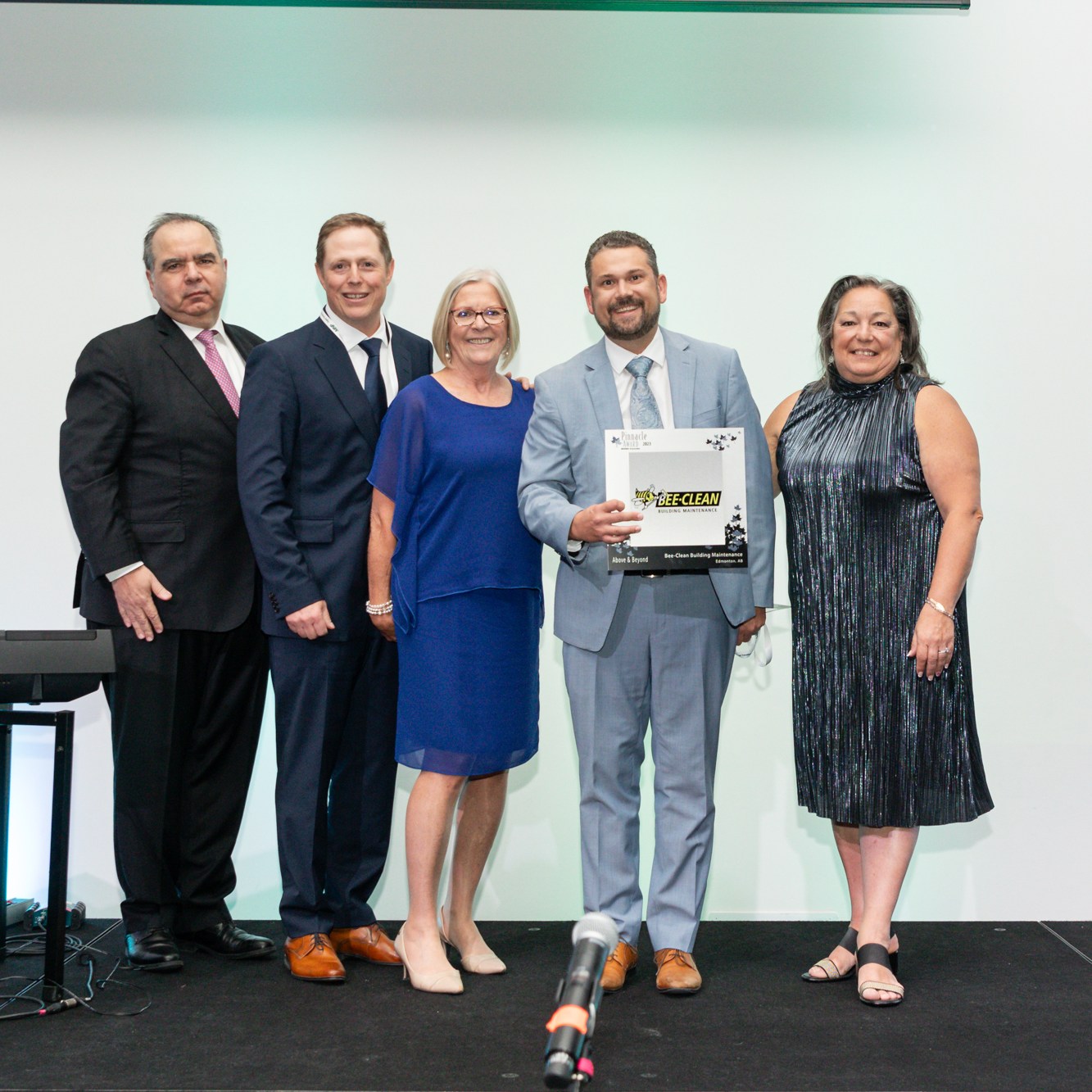 Image description: Group photo of 5 people, The presenters and winners are in front of the white background. Text reads: BEE-CLEAN