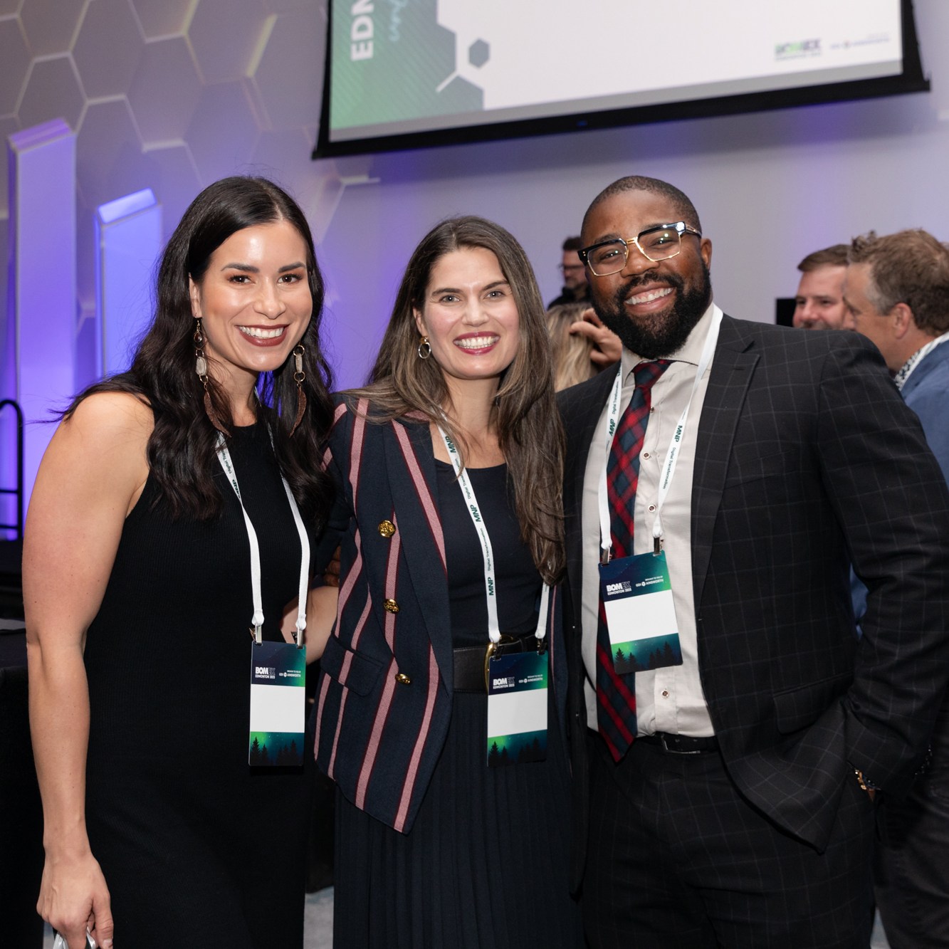 Image description: Group photo of two women and a man at a business meeting. Text reads: BOMEX2023