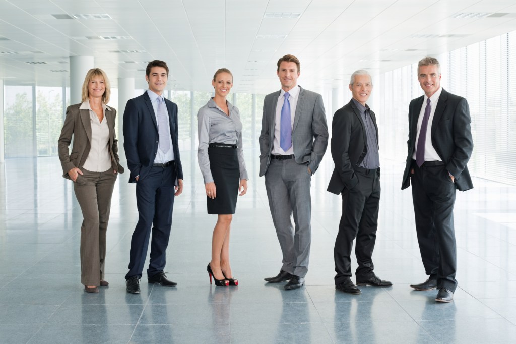 Full body shot of two women and four men.